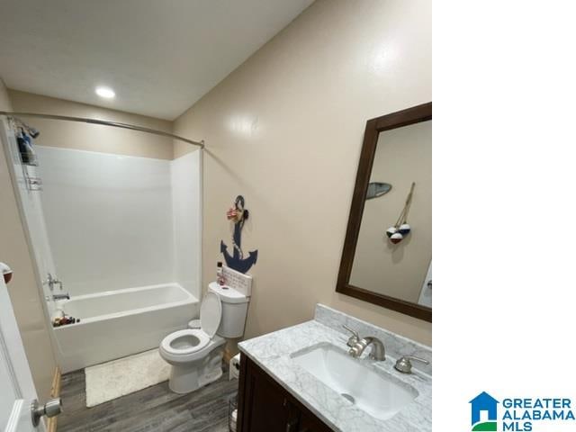 full bathroom with hardwood / wood-style floors, oversized vanity, shower / tub combination, and toilet