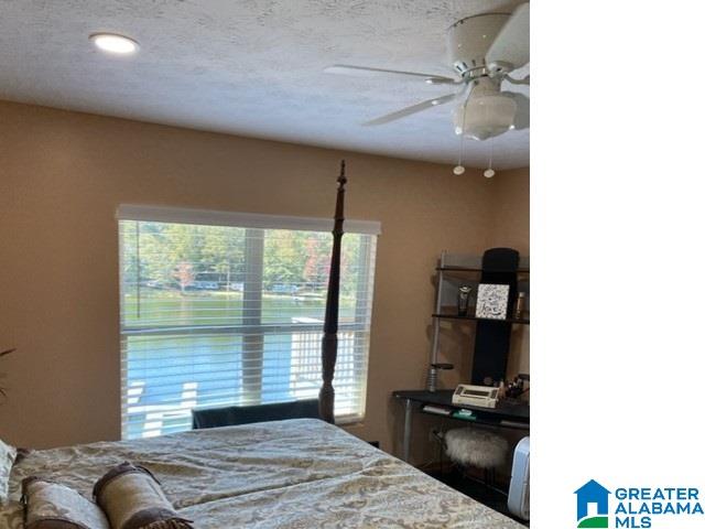 bedroom with a textured ceiling and ceiling fan