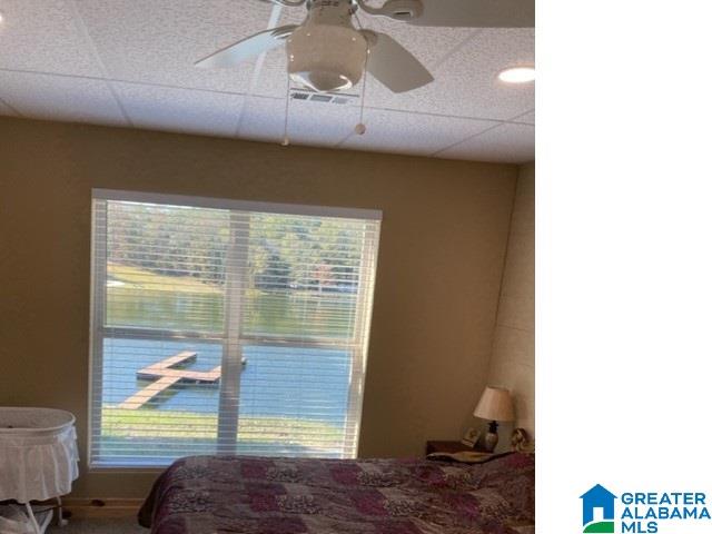 bedroom with a drop ceiling and ceiling fan