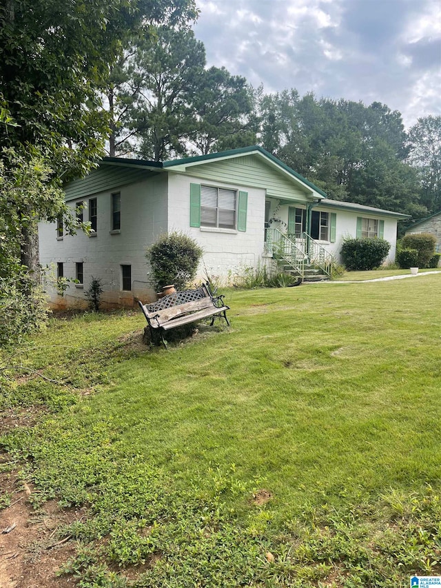 rear view of house featuring a yard