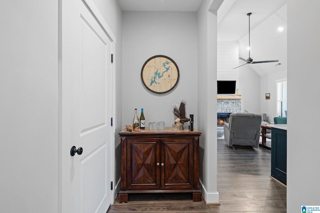 hallway with lofted ceiling and dark wood-type flooring