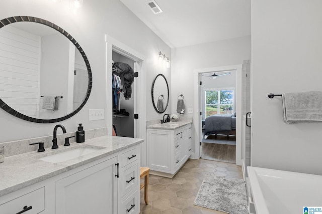 bathroom featuring tile flooring, a tub, and dual bowl vanity