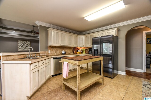 kitchen with ornamental molding, sink, dishwasher, and black fridge with ice dispenser