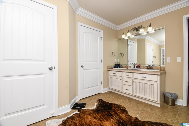 bathroom featuring ornamental molding, tile flooring, large vanity, and dual sinks