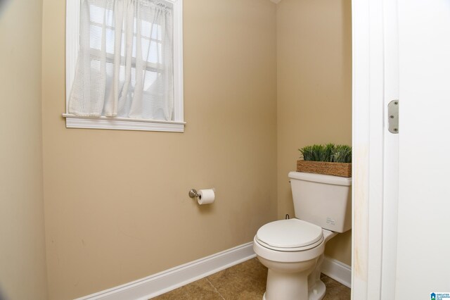 bathroom with toilet and tile floors