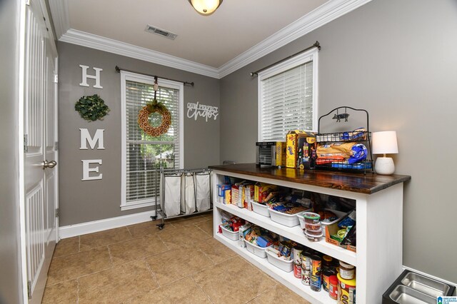 interior space with ornamental molding and tile floors