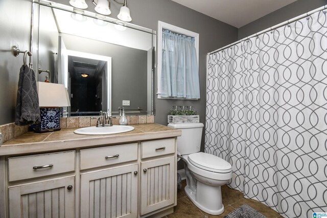 bathroom with toilet, tile floors, and vanity