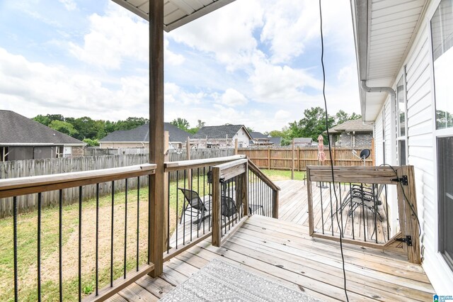 wooden terrace featuring a lawn