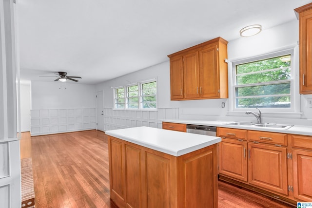 kitchen with a center island, stainless steel dishwasher, sink, hardwood / wood-style flooring, and ceiling fan