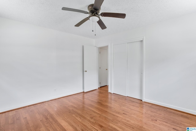 unfurnished bedroom featuring light hardwood / wood-style flooring, ceiling fan, a textured ceiling, and a closet