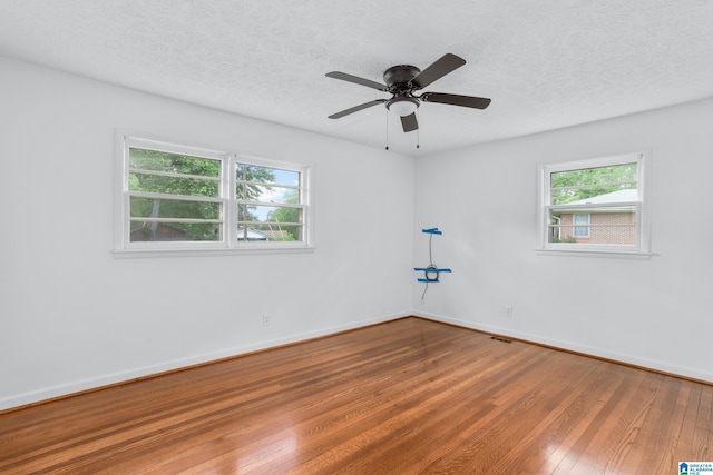 spare room featuring a textured ceiling, ceiling fan, and hardwood / wood-style flooring