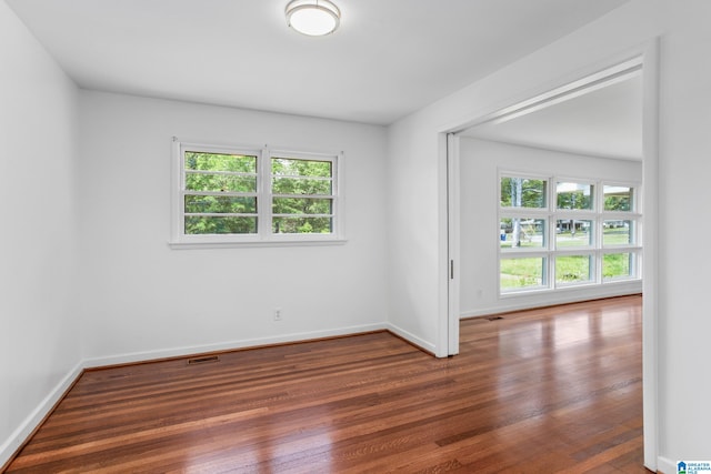 unfurnished room with dark hardwood / wood-style floors