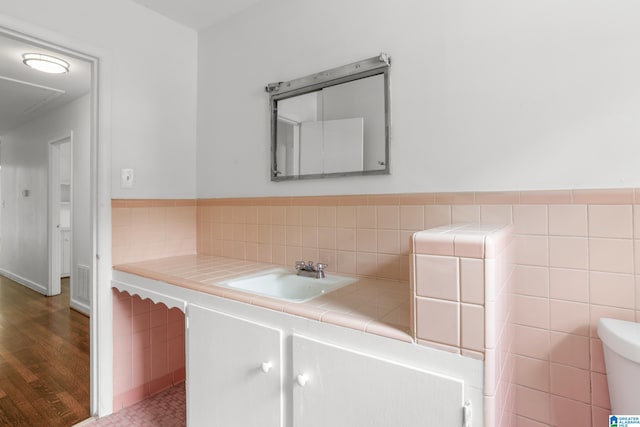 bathroom featuring tile walls, oversized vanity, backsplash, toilet, and wood-type flooring