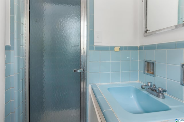 bathroom featuring tasteful backsplash, tile walls, sink, and plus walk in shower