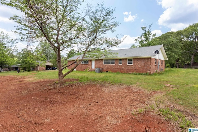 back of property featuring central air condition unit and a lawn