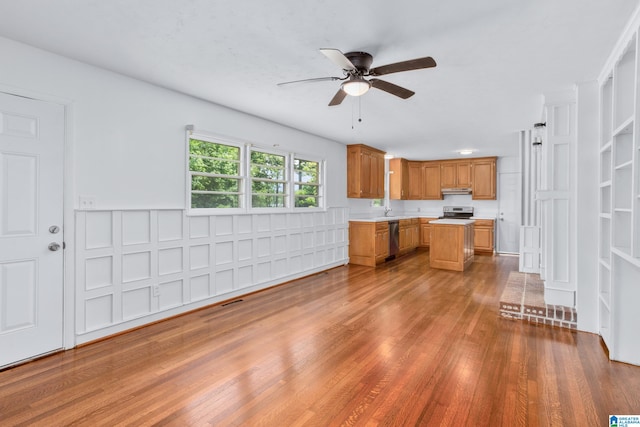 kitchen with hardwood / wood-style flooring, appliances with stainless steel finishes, ceiling fan, and sink