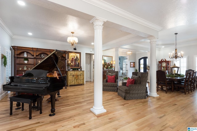 miscellaneous room featuring ornamental molding, a chandelier, light hardwood / wood-style flooring, and decorative columns