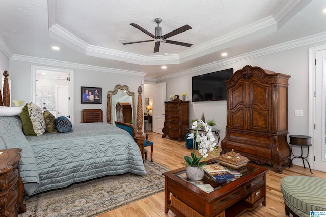 bedroom with ceiling fan, a raised ceiling, light hardwood / wood-style floors, and crown molding