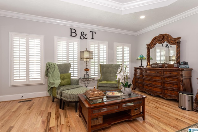 sitting room with light wood-type flooring, a wealth of natural light, and ornamental molding