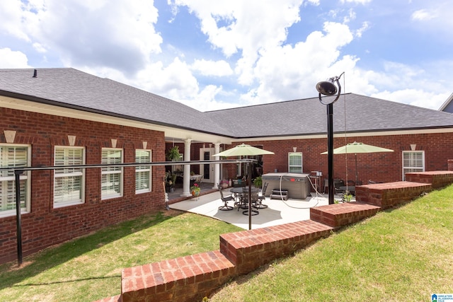 rear view of house with a yard and a patio