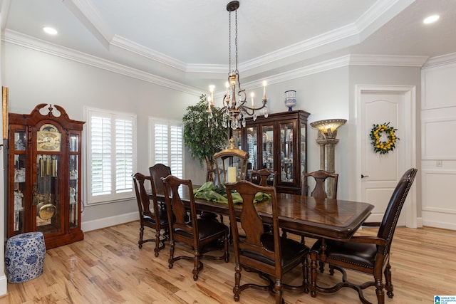 dining area with light hardwood / wood-style floors, a notable chandelier, and ornamental molding