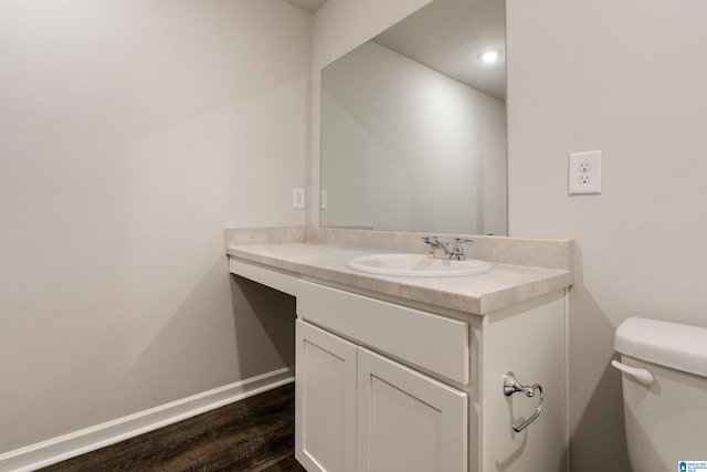 bathroom with hardwood / wood-style floors, vanity, and toilet