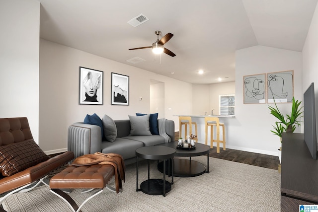 living room with ceiling fan, wood-type flooring, and vaulted ceiling