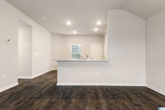 empty room with vaulted ceiling and dark hardwood / wood-style floors