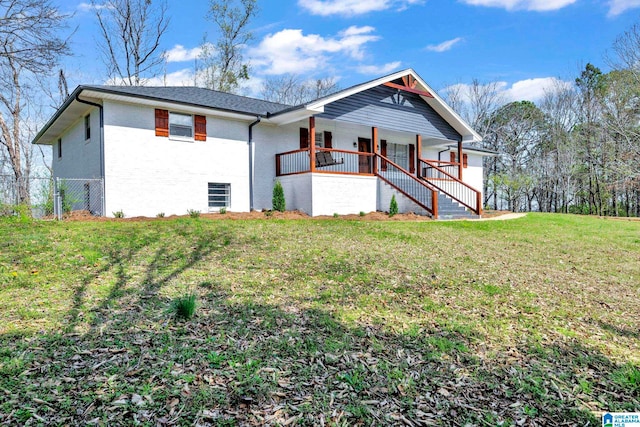 view of front of house featuring brick siding, stairs, fence, a porch, and a front yard