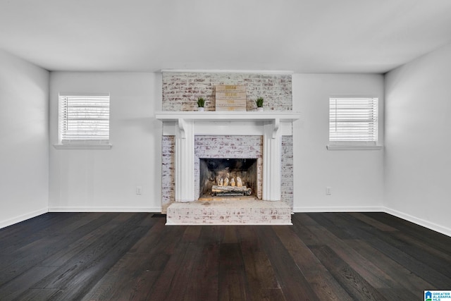 unfurnished living room with a fireplace, a wealth of natural light, and dark hardwood / wood-style floors