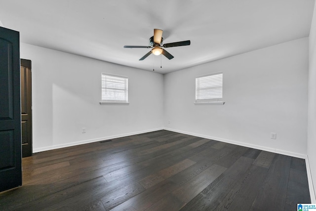 unfurnished room with ceiling fan, a wealth of natural light, and dark hardwood / wood-style floors