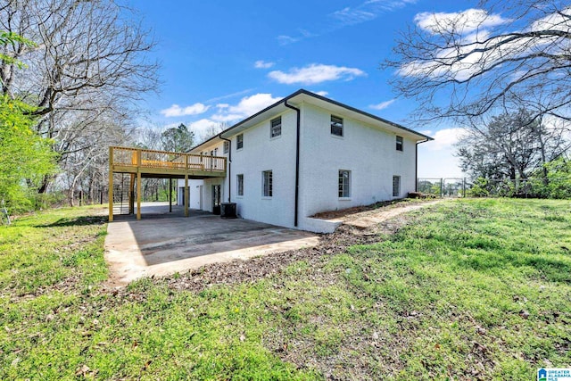 back of property featuring a lawn, a patio area, and a deck