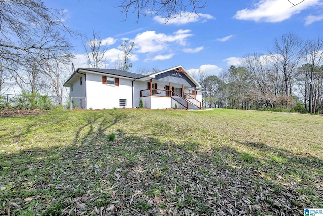 back of house featuring stairs, fence, and a lawn