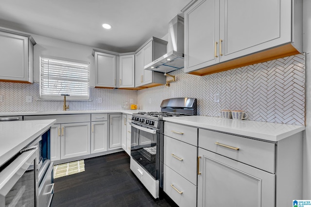 kitchen with stainless steel gas stove, dark wood-type flooring, backsplash, and wall chimney range hood