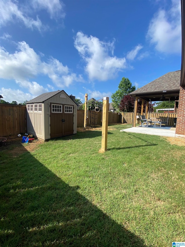 view of yard with ceiling fan, a patio, and a storage unit