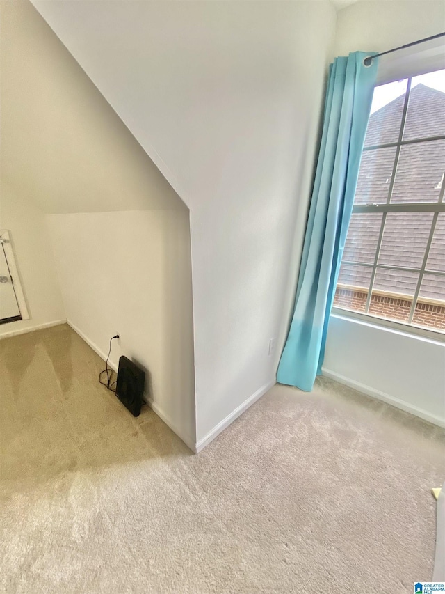 carpeted empty room featuring lofted ceiling