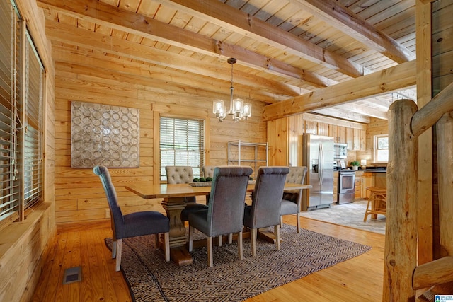 dining room with wood ceiling, wood walls, and light hardwood / wood-style floors