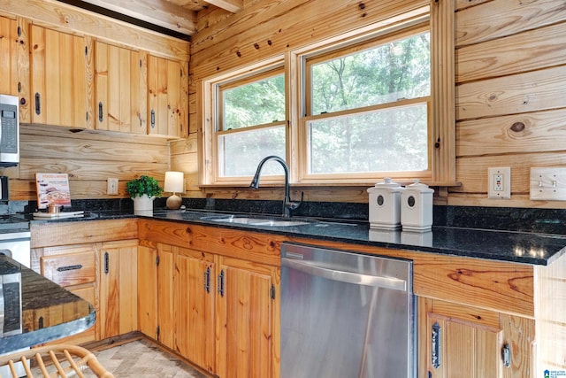 kitchen featuring dark stone countertops, stainless steel appliances, and sink