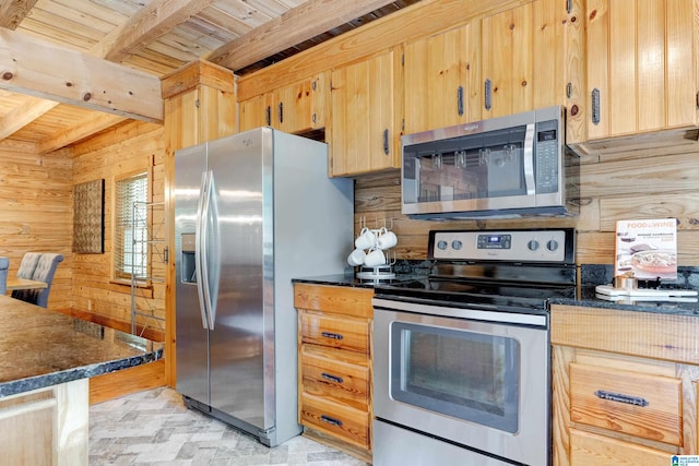 kitchen featuring appliances with stainless steel finishes, wooden walls, and beam ceiling