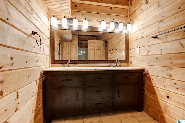 bathroom with double sink vanity, wood walls, and tile flooring