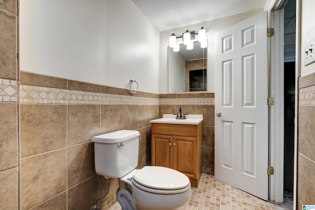 bathroom featuring tile walls, vanity, tile floors, and toilet