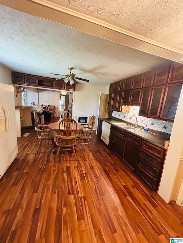 kitchen with sink, backsplash, ceiling fan, dark wood-type flooring, and a textured ceiling