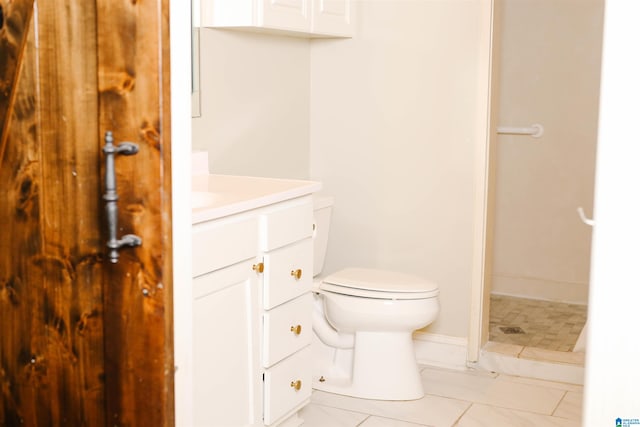 bathroom featuring vanity, tile patterned flooring, toilet, and a shower