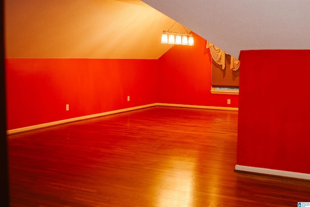 additional living space with lofted ceiling and hardwood / wood-style floors