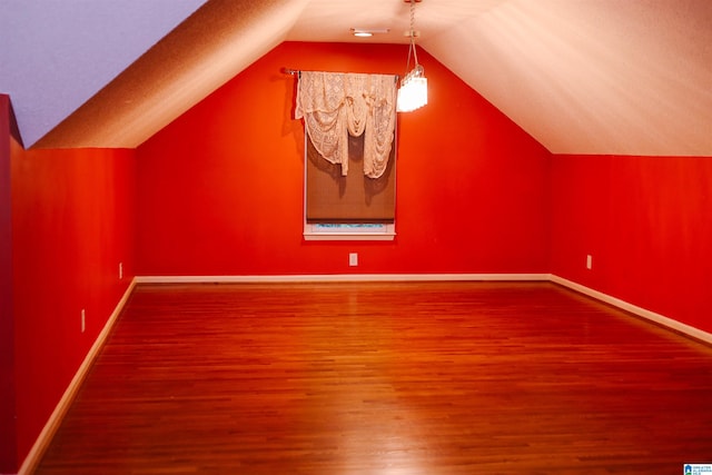 bonus room with hardwood / wood-style floors, vaulted ceiling, and a textured ceiling