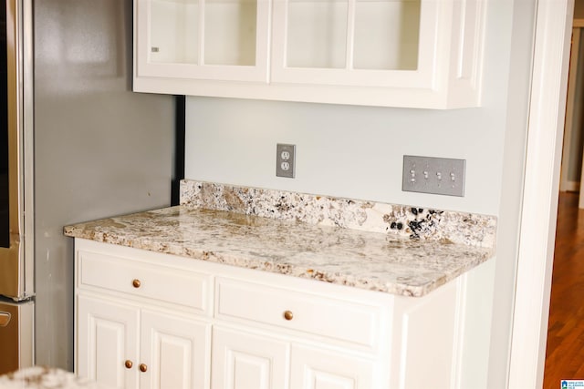 interior space with white cabinetry and light stone countertops