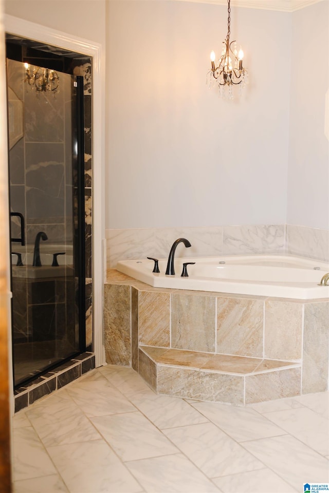 bathroom with tiled bath and a chandelier