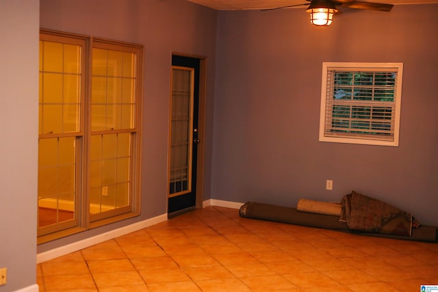 tiled empty room featuring ceiling fan