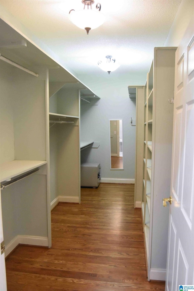 walk in closet with hardwood / wood-style floors