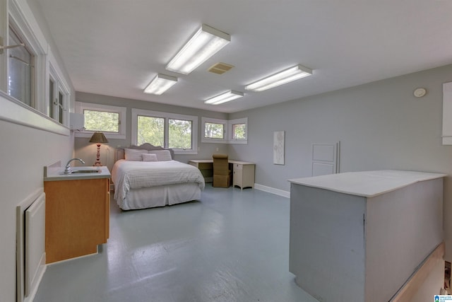 bedroom featuring sink and concrete floors